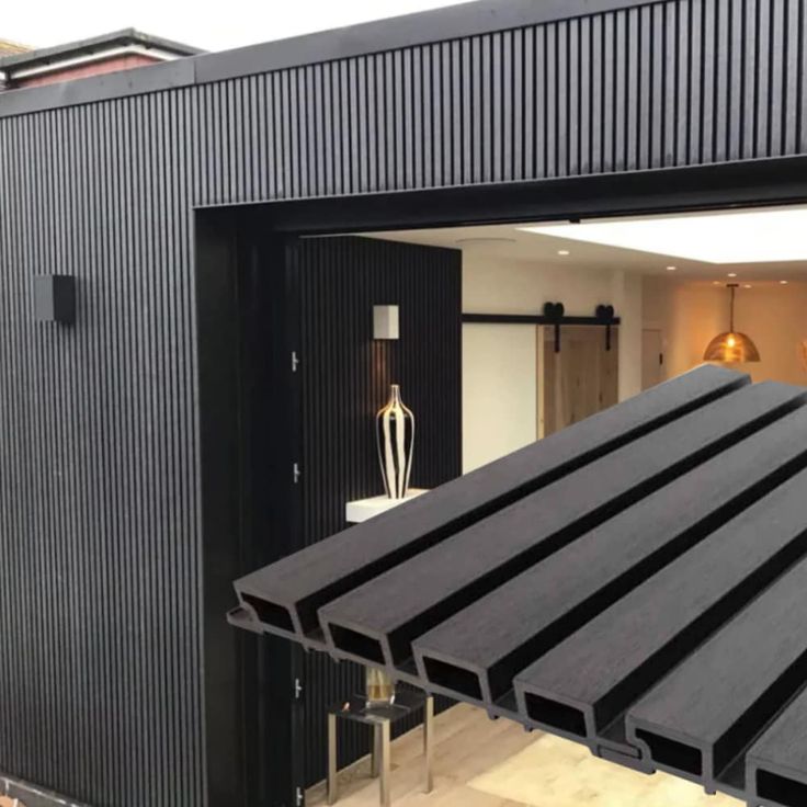 an open garage door with black siding on the outside