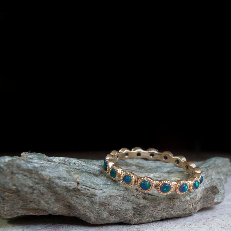 An exceptional Eternity ring Hand made in 9, 14 or 18 Karat Yellow Gold Set in a Crown Setting with 2mm Cabochon Green-Blue Opals all around the band. These gemstone are remarkable and the photos cannot truly pass their beauty. Each Ring will feature between 15-22 Gemstones (Depending on ring size). Each Ring will be perfect and made from Scratch in your desired ring Size. All Questions and custom requests welcome. Stone count is subject to Ring size The ring width is: 3 mm / 0.11 inches Each Op Fine Jewelry Stackable Halo Rings, Fine Jewelry Halo Stackable Rings, Bezel-set May Birthstone Jewelry, May Birthstone Round Band Jewelry With Bezel Setting, May Birthstone Jewelry With Bezel Setting In Round Band, 14k Gold Halo Jewelry For May Birthstone, May Birthstone Stackable Round Stone Jewelry, Stackable May Birthstone Jewelry With Round Stones, Adjustable Opal Ring For Anniversary