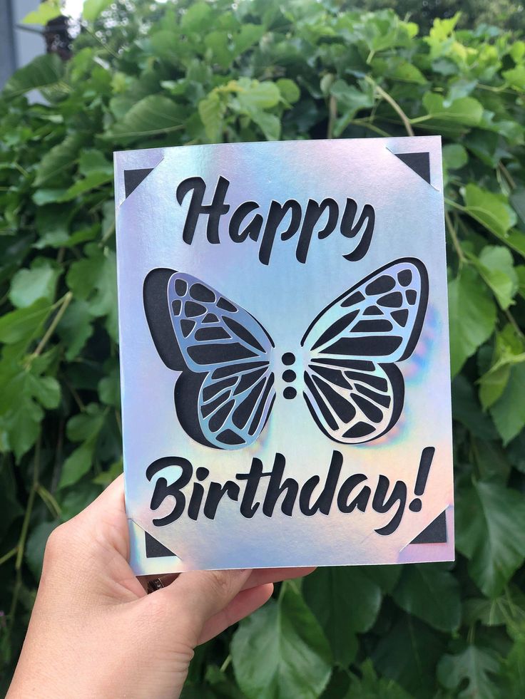 someone holding up a card with a butterfly on it that says happy birthday in black and white