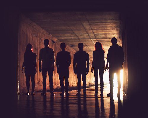 a group of people standing next to each other in front of a body of water