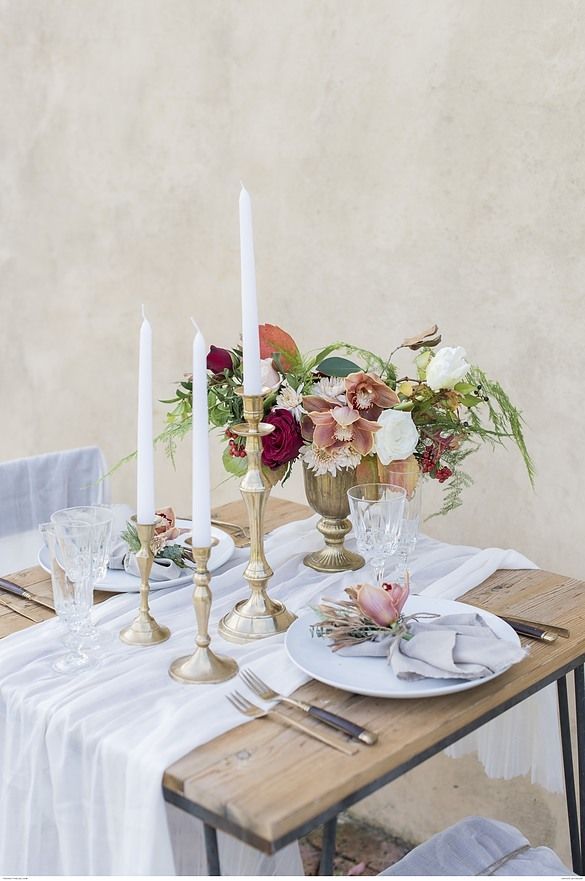 the table is set with flowers and candles