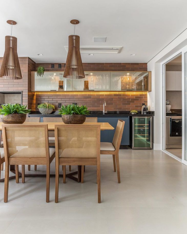 a dining room table and chairs with plants in the center, next to an open kitchen