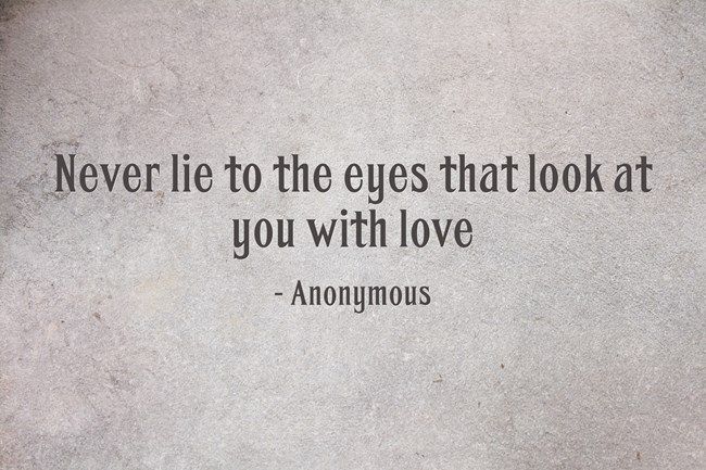 a quote from an unknown person on the side of a wall that says, never lie to the eyes that look at you with love