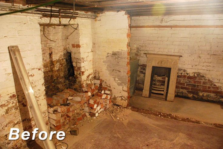 an unfinished room with exposed brick walls and a fire place in the corner, before and after remodeling