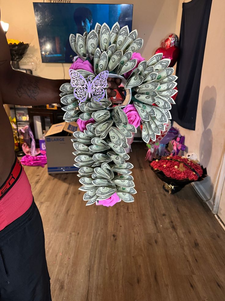 a woman is holding a bunch of money in her hand while standing on the floor