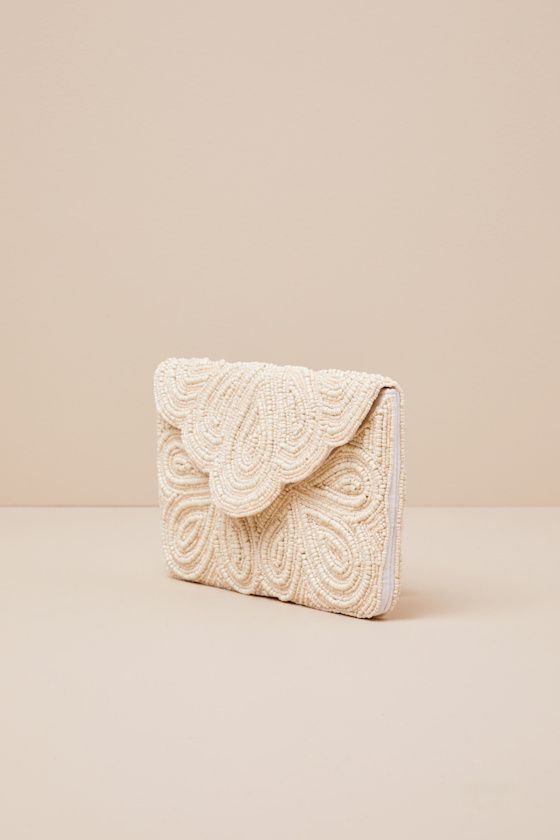 Make your perfect day complete with the Lulus Stunning Addition White Beaded Clutch! Stunning white and ivory beads intricately adorn this clutch with an envelope-style flat with scalloped edges. The magnetic closure opens to reveal a lined interior with a sidewall pocket. Gold chain strap. Fully lined. Clutch measures 9. 5" wide, 6" tall, and 0. 75" deep (relaxed). 44" gold chain strap. Strap has 21" drop. 80% Glass, 20% Iron Metal. Shell: 100% Polyester. Lining: 100% Cotton. Spot Clean Only. I Boho Clutch Bag, Bridal Clutch Purse, Bridal Clutch Bag, Prom Clutch, Clutch Pattern, Boho Clutch, Bride Bag, Bridal Purse, White Clutch