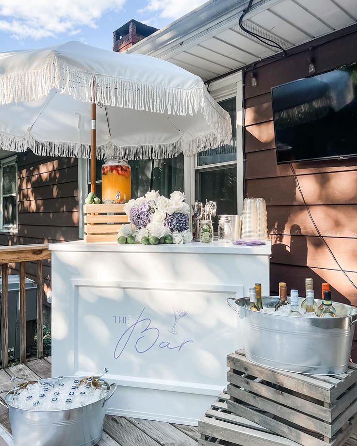 an ice cream stand on a wooden deck with flowers and candles in the buckets