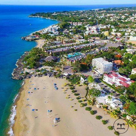 an aerial view of the beach and resort area in front of the ocean with blue water