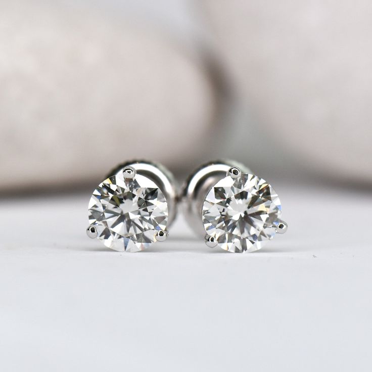 These timeless and elegant stud earrings are a true staple in any girl's jewelry box! 3 prong "cocktail style" setting Set with stunning lab grown diamonds Choose your center lab grown diamond: Better: an eye-clean diamond that's very slightly warm in color (SI+ clarity, GHI color) Best: an impeccable diamond, that's completely colorless (VS+ clarity, DEF color) Earrings weighing 1.00ct (total per pair) or above are crafted with threaded screw back posts, to ensure you never loose them. You're w Minimalist Solitaire Diamond Earrings, Minimalist Solitaire Cubic Zirconia Diamond Earrings, Elegant Round Cut Diamond Earrings With Tension Setting, Minimalist Cubic Zirconia Solitaire Diamond Earrings, Timeless Tension Setting Earrings For Anniversary, Timeless Earrings With Tension Setting For Anniversary, Minimalist Solitaire Diamond Earrings In White Gold, Minimalist Solitaire Sterling Silver Diamond Earrings, Classic White Gold Diamond Earrings With Tension Setting