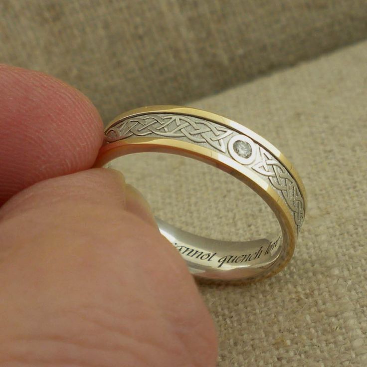 someone is holding their wedding ring in their left hand and it has an engraved message on the side