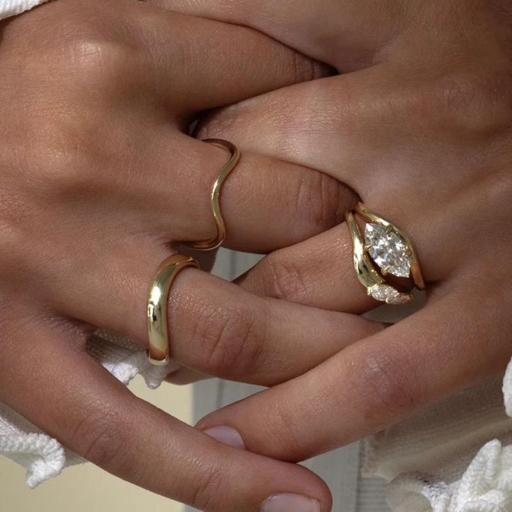 two people holding hands with rings on their fingers