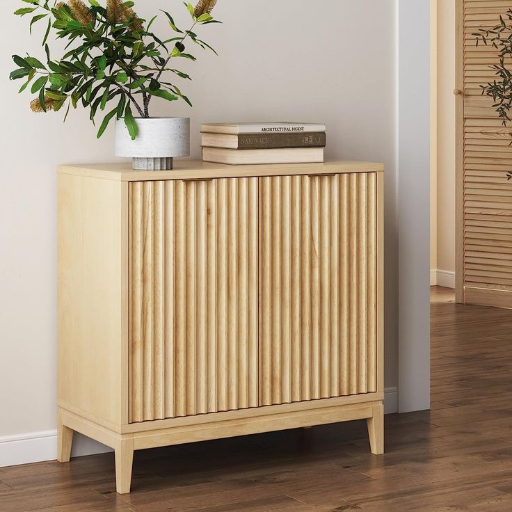 a plant sitting on top of a wooden cabinet