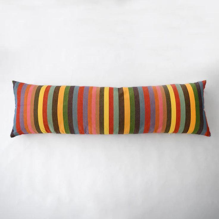 a multicolored striped pillow on a white background with the bottom half turned down