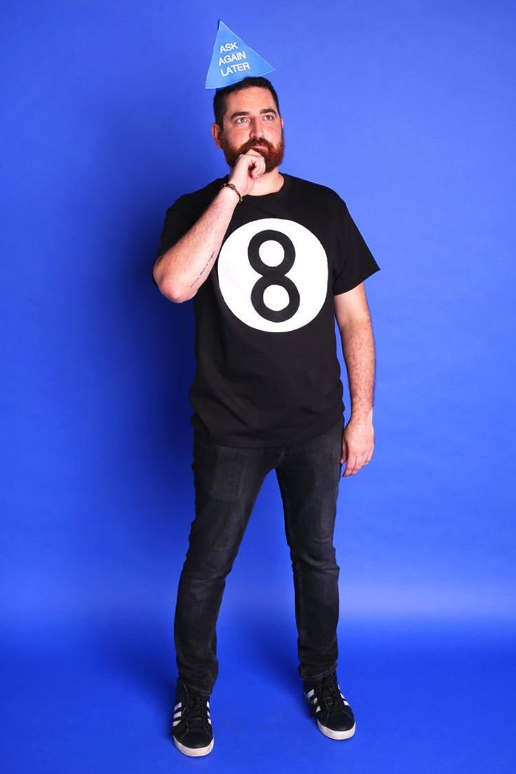 a man in a black shirt with a blue party hat on his head is posing for the camera