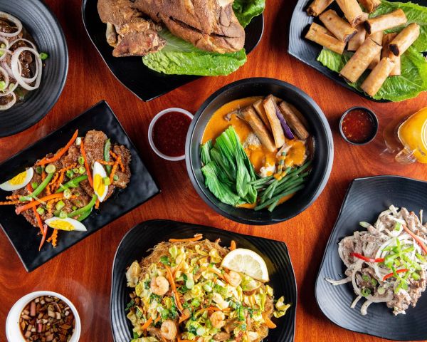 a table topped with black plates filled with food