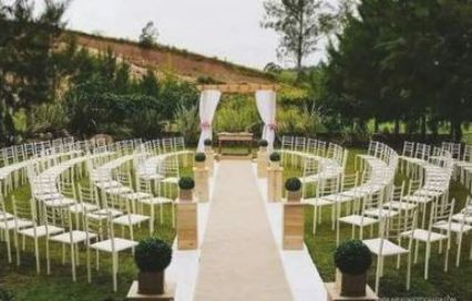 an outdoor ceremony setup with white chairs