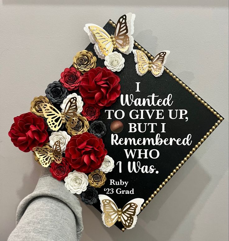 a decorated graduation cap with flowers and butterflies on the top reads i wanted to give up but i remembers who i was