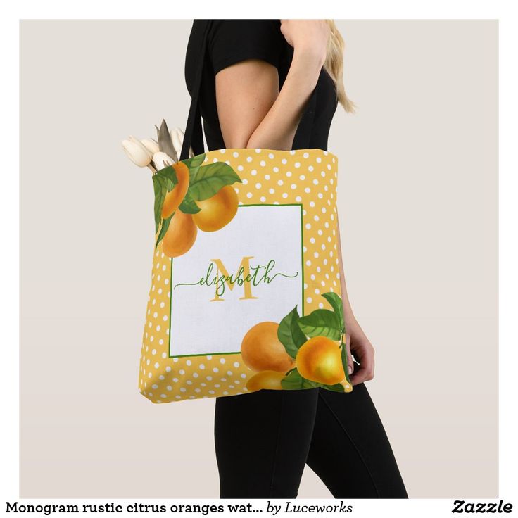 a woman carrying a yellow tote bag with oranges on it