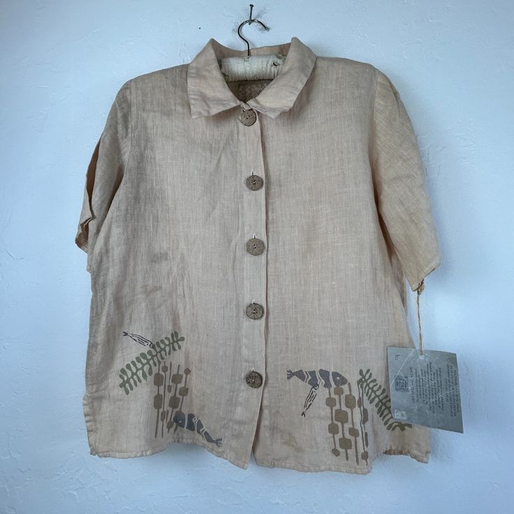 an old shirt hanging on a wall with a tag attached to the back of it