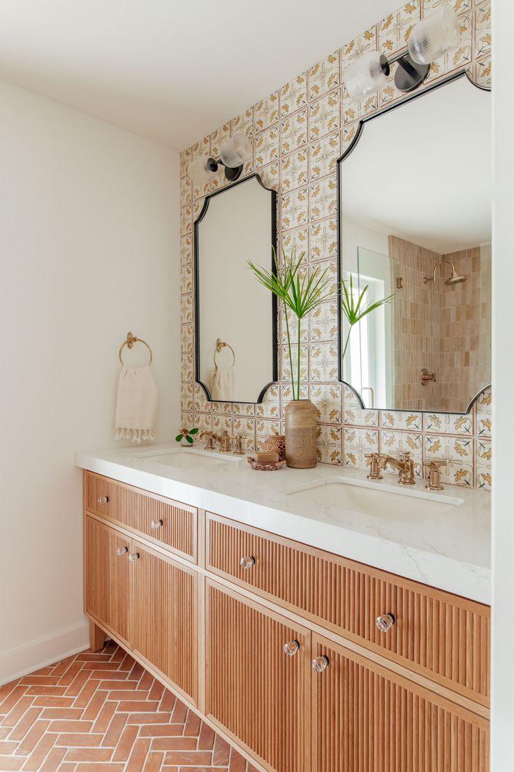 a bathroom with two sinks and large mirrors on the wall next to eachother