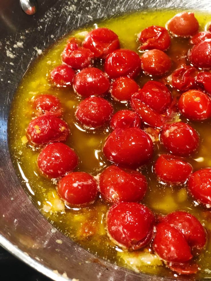 tomatoes are being cooked in oil in a pan