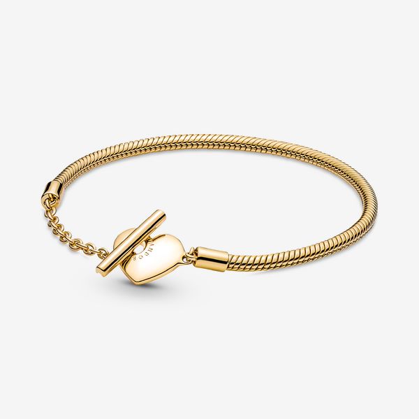 Add a luxurious touch to your loved one’s collection with the Pandora Moments Heart T-Bar Snake Chain Bracelet. Hand-finished in 14k gold plating, this piece is inspired by our classic Pandora Moments T-bar snake chain bracelet. The style features a heart-shaped disc with an open circle on one side to loop the T-bar through to open and close, while the reverse side is polished. Designed to be styled with 10-13 charms, include your very own personal message for a heartfelt finish. - Pandora Moments Heart T-Bar Snake Chain Bracelet - 14k Gold-plated unique metal blend - Sz. 6.3 in Bracelet Pandora, Snake Chain Bracelets, Silver Snake Chain, Bar Bracelets, Gold Bracelet Chain, Pandora Bracelets, The Avengers, Pandora Bracelet, Pandora Jewelry