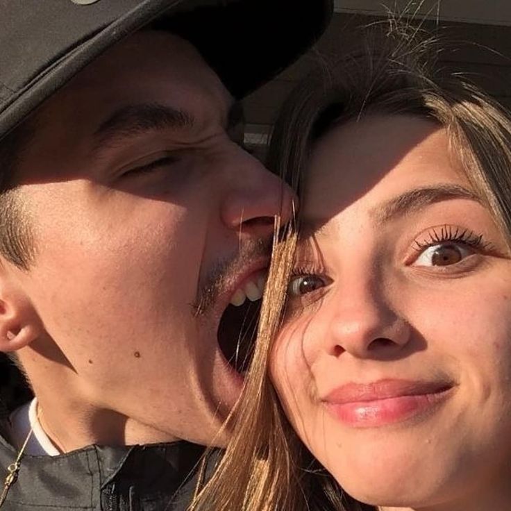 a man and woman kissing each other in the back seat of a car with their mouths open