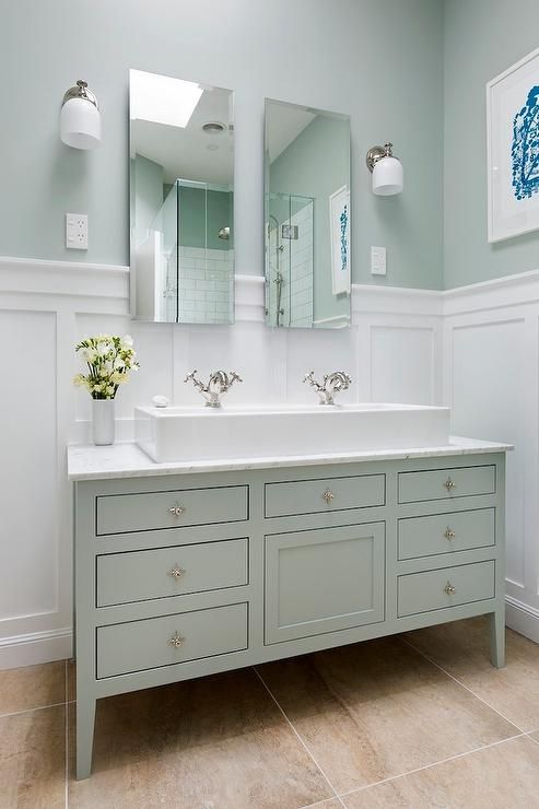 a bathroom with two sinks and mirrors in the wall above them is painted light blue