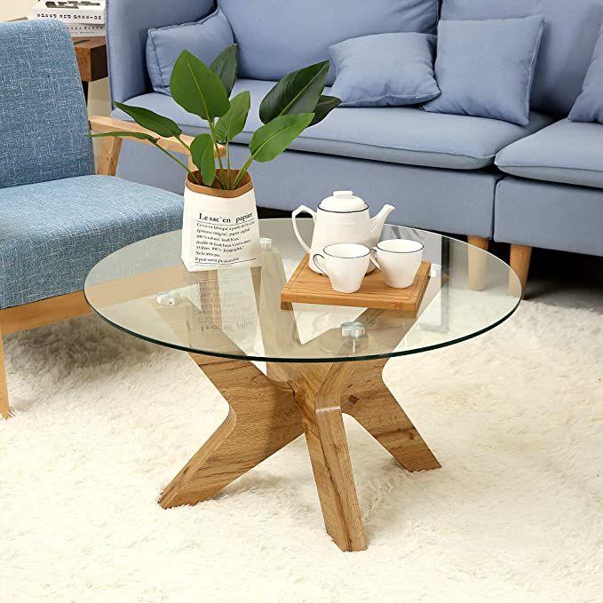 a glass table with two chairs and a couch in the background