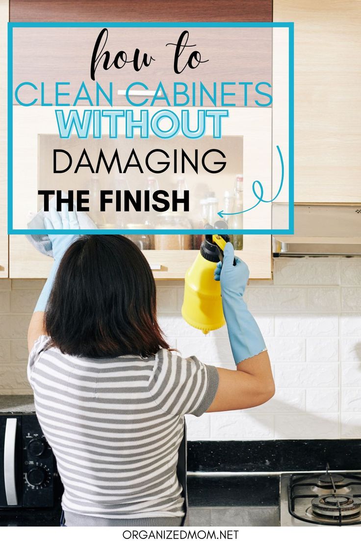 a woman in striped shirt cleaning kitchen cabinets with yellow gloves and blue mitts on