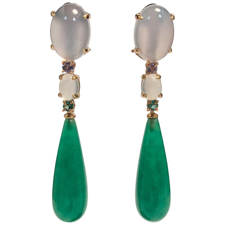 Discover these magnificent earrings in 18-carat yellow gold, a true work of art that harmoniously combines jade, tanzanite, chalcedony and emerald. Every detail of these earrings has been carefully designed to offer striking aesthetics and exceptional brilliance. 18-carat yellow gold, with its warm glow, creates a solid, luxurious base for these earrings. It also adds a touch of richness and elegance to the ensemble. The gemstones adorning these earrings are simply breathtaking. Jade, with its s Rose Gold Chandelier, Rose Gold Chandelier Earrings, Chandelier Contemporary, Emerald Earrings Drop, Diamond Chandelier Earrings, Gold Chandelier Earrings, Tanzanite Earrings, Jade Earrings, Gold Chandelier