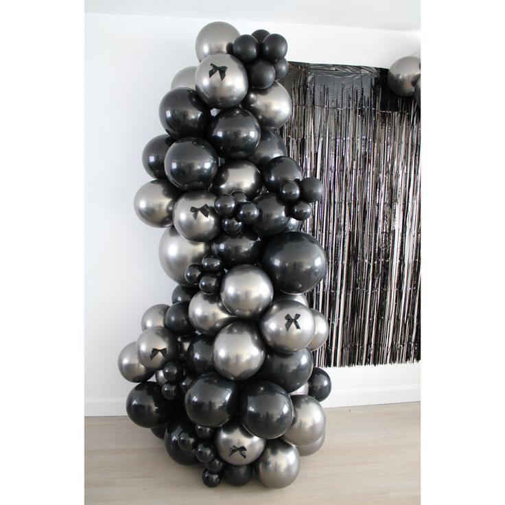 a bunch of black and silver balloons in the shape of a pyramid