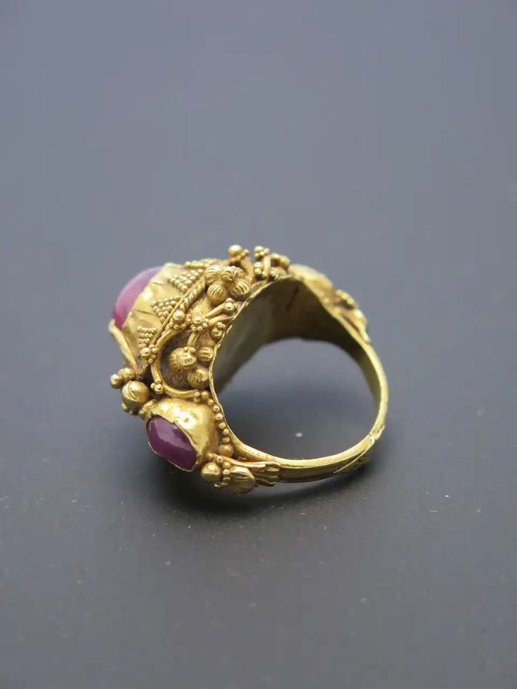 For Sale on 1stDibs - Finely worked in high karat gold (22k+) and featuring three rough cut ruby cabochons ranging form light pink to purplish pink, typical of rubies from Indonesia. Traditional Ruby Ring In Yellow Gold, Oval Gold Ruby Ring For Ceremonial Occasions, Oval Ruby Ring In Gold For Ceremonial Occasions, Antique Multi-stone Gold Ruby Ring, Antique Gold Multi-stone Ruby Ring, Antique Multi-stone Ruby Ring In Gold, Ceremonial Yellow Gold Ruby Ring, Traditional Yellow Gold Ruby Ring With Gemstone, Traditional Oval Ruby Ring