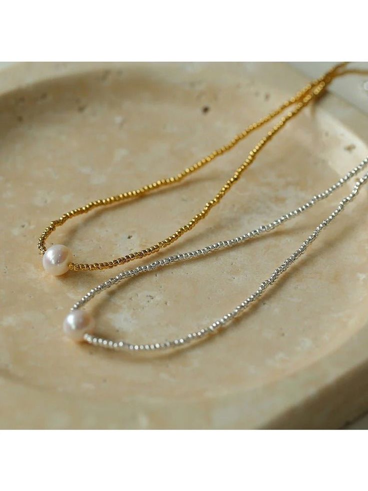 Elevate a timeless classic with a refined touch. This versatile piece effortlessly combines the gentle elegance of gold/silver beads with the soft charm of pearls. With every movement, the delicate beads catch the light and exude a captivating aura. A slightly blemished natural pearl is set in the center, adding a unique touch of charm. Its luster is most dazzling under dim light, giving off a charming aura. Metal: 18K Recycled Gold Plated On Brass/Recycled Sterling Silver Plated On Brass Gemstone: Freshwater Pearl Pearl Dimensions: 9-9.5mm Necklace Length: 400-450mm Weight: 6.5g Classic Beaded Pearl Necklace, Elegant Pearl Necklace With Delicate Chain And Round Beads, Timeless Gold Pearl Necklace With Round Beads, Timeless Gold Pearl Necklace With Delicate Chain, Gold Refined Pearl Necklace, Gold Pearl Necklace With Tiny Beads As Gift, Gold Pearl Necklace With Tiny Beads For Gift, Everyday Gold Pearl Necklace With Tiny Beads, Silver Dainty Beaded Pearl Necklace