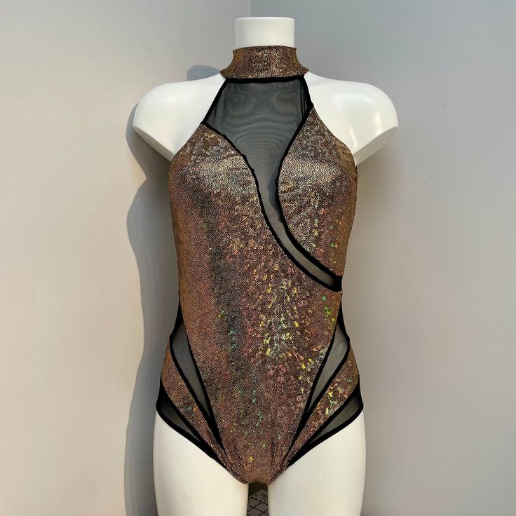 a mannequin wearing a gold and black bodysuit with sheer mesh on it