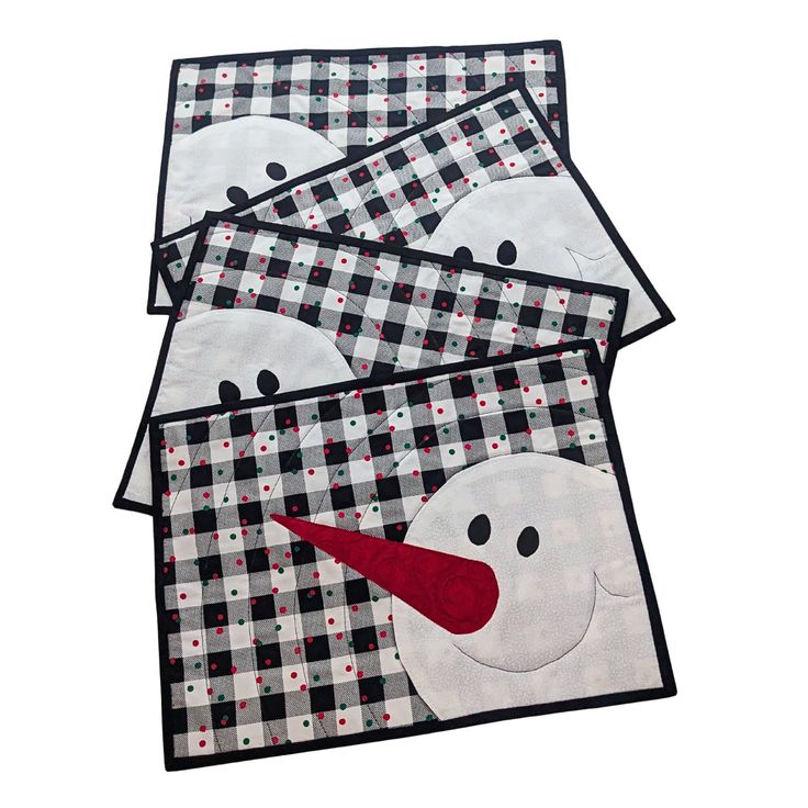 three snowman placemats with black and white checkered fabric, one has red nose