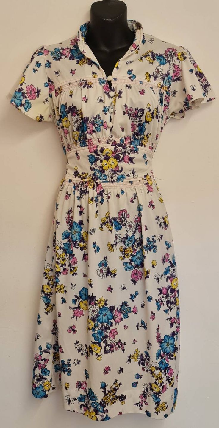 Absolutely beautiful 1970s dress made by jc penny's. The floral design and feel of this is just perfect for the summer. Condition is amazing no marks or defects there was some yellowing on one sleeve you might see in the pictures but that came out with a hand wash. Size is unmaked but would say its about a medium. Mesurements are taken with garment laying flat. Waist - 19 inches (tie waist so can go smaller) Bust - 17 inches  Hips - 20.5 inches (estimate) Waist to hem - 20.5 Underarm to cuff - 1 inches  Back of collar to hem - 41 inches  Thanks for looking and if you have any questions please don't hesitate to ask 😊 Vintage Floral Short Sleeve Dress For Spring, Vintage Floral Print Dress With Short Sleeves, Vintage Floral Dress With Short Sleeves For Spring, Vintage Floral Short Sleeve Dress For Summer, Vintage Floral Dress With Short Sleeves For Summer, Cream Dresses With Ditsy Floral Print For Summer, Vintage Floral Print Sundress For Summer, Vintage Floral Sundress For Summer, Vintage Floral Dress For Spring Daywear