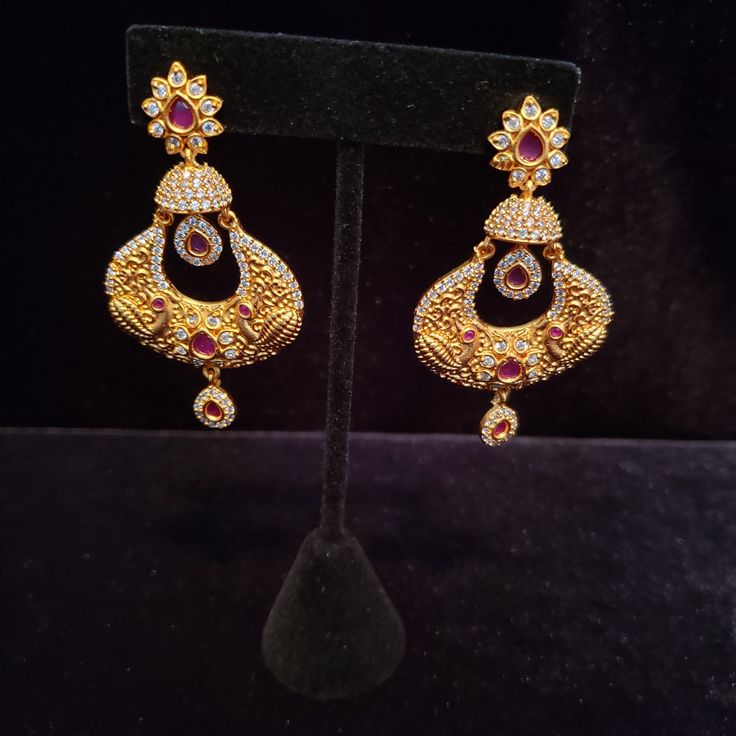 "These Jhumka Earrings set have an excellent finish and gives out an exquisite sense of style. If you are looking for an amazing Fashion Jewelry set for special occasions such as Anniversary, Engagement, Party, Wedding or for gifting , then your search ends here. Handmade Indian Temple Jewelry, best to wear it for traditional ceremonies or Indian wedding. This bridal jewelry has ethnic finish. It has Cubic Zircon stones with ruby and emeralds. It is a Bollywood style one gram jewelry. There are Elegant Jeweled Earrings For Diwali, Traditional Jeweled Dangle Danglers, Jeweled Drop Earrings For Festivals, Jeweled Drop Danglers For Festivals, Festive Jeweled Bridal Earrings For Formal Occasions, Elegant Jeweled Danglers For Celebrations, Peacock Design Drop Earrings For Party, Festive Chandbali Jeweled Bridal Earrings, Festive Jeweled Chandbali Earrings