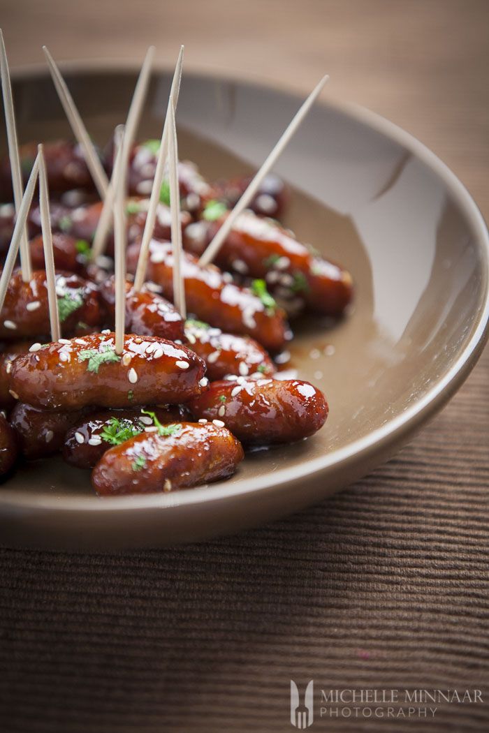 the plate has several skewered meats on it with toothpicks in them