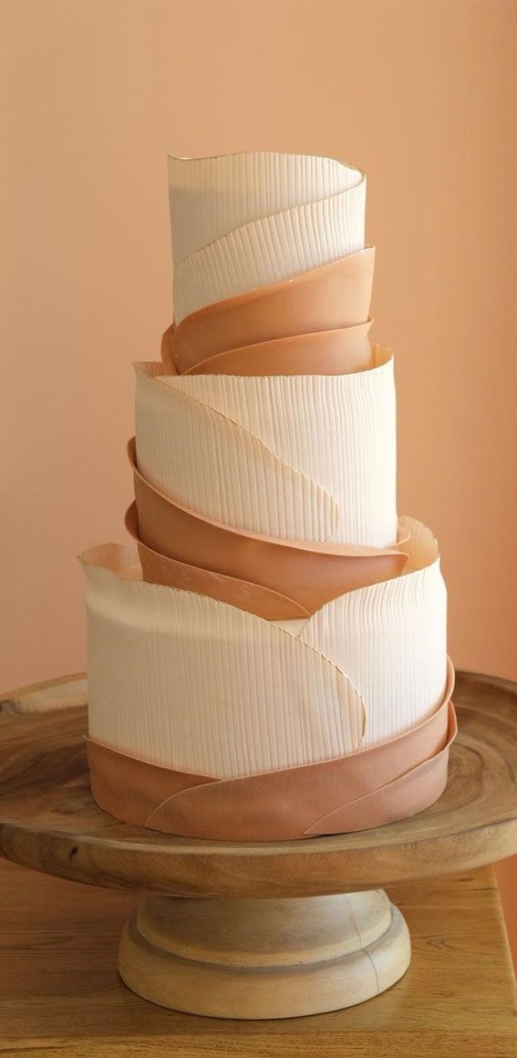 a three tiered cake sitting on top of a wooden plate