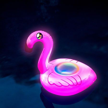 a pink flamingo floating in the water at night