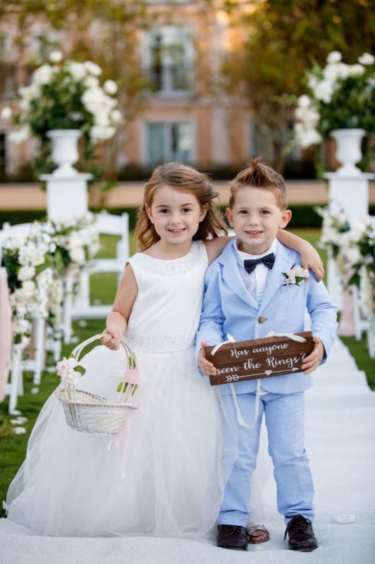 two young children dressed in blue and white standing next to each other at a wedding