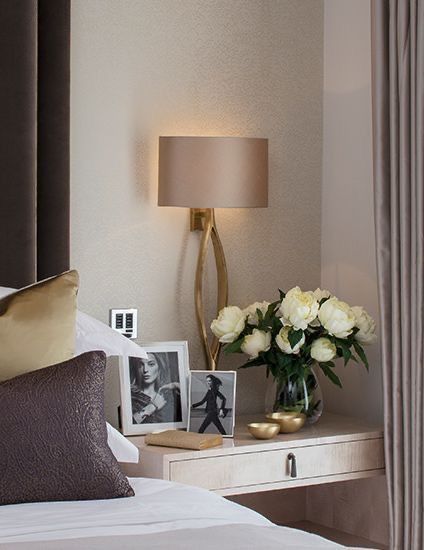 a bedroom with flowers and pictures on the nightstand