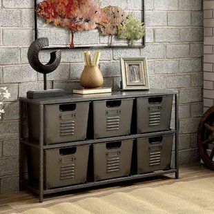 an industrial style storage unit with four bins and a painting on the wall behind it