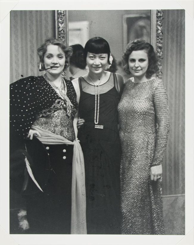 three women standing next to each other in front of a mirror