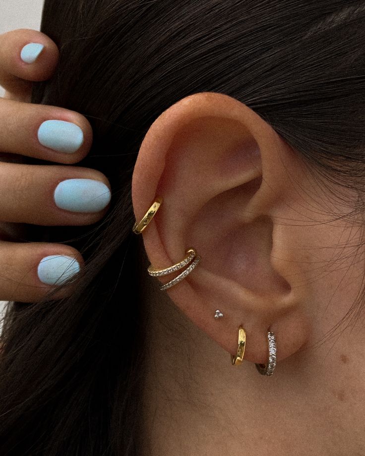 a close up of a person's ear with two different rings on top of it