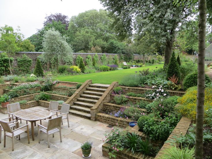 an outdoor patio with steps and tables surrounded by greenery