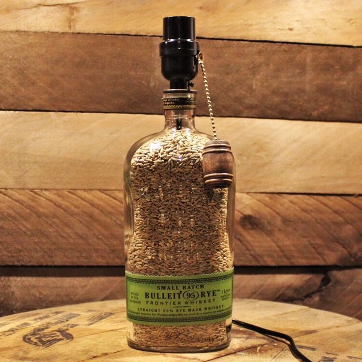 a bottle filled with sand sitting on top of a wooden table