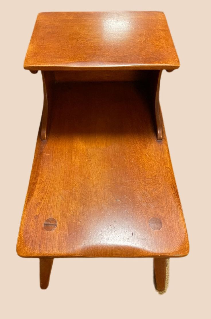 a small wooden table with one shelf on the top and two legs at the bottom