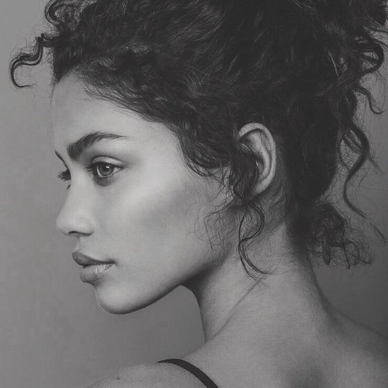 a black and white photo of a woman with curly hair